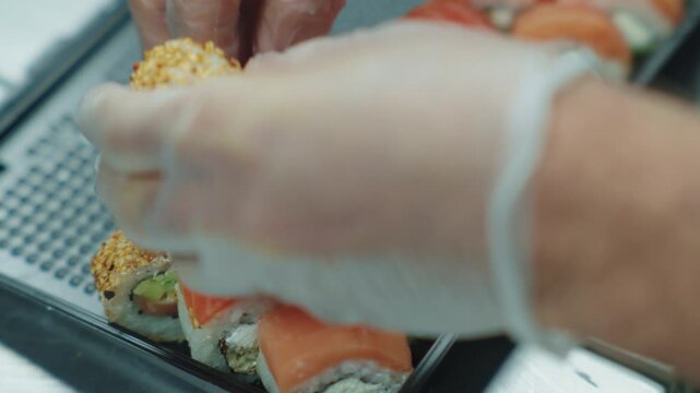 
A sushi chef rolls sushi ingredients. Japanese food. Sushi preparation.