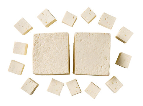 Fresh firm tofu blocks and scattered cubes, a healthy plant-based protein source isolated on transparent background, ready for cooking