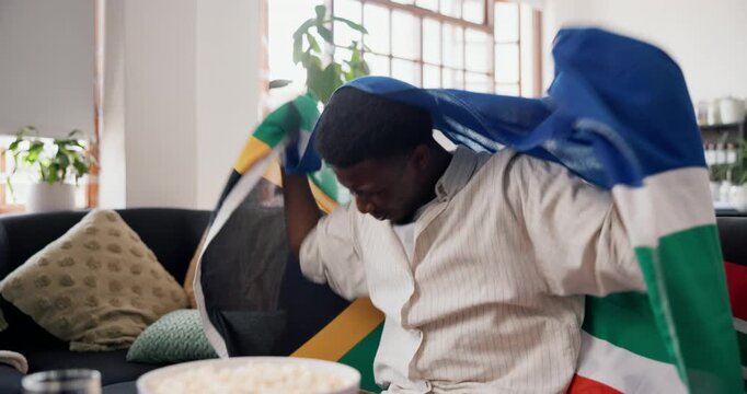 Celebrate, south african flag or black man watching tv on sofa, sports competition or soccer game win. Live stream, football fan or person cheering for tournament goal in home, match success or happy