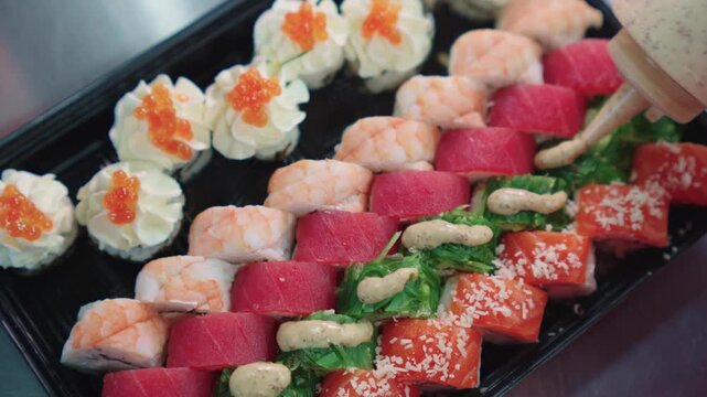 Sushi set. Japanese food. A sushi chef decorates and decorates a sushi set with various toppings. Sushi preparation.