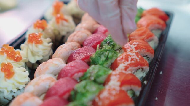 Sushi set. Japanese food. A sushi chef decorates and decorates a sushi set with various toppings. Sushi preparation.