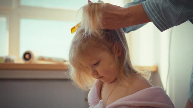 In serene home setting, loving mother gently combs styles her child's hair into neat twin ponytails, exuding warmth tender care, her patient touch testament to special bond between mother little girl