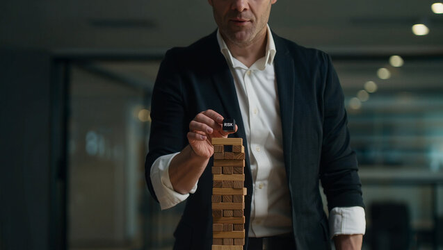 Businessman Concentrating During Jenga Game in Office