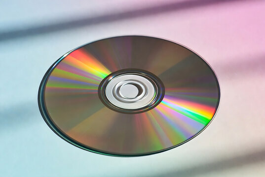 A CD rests on a pink and blue textured background.