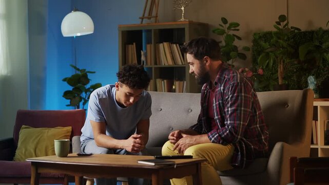 Strict father scolding his teenage son for bad grades, disciplining child