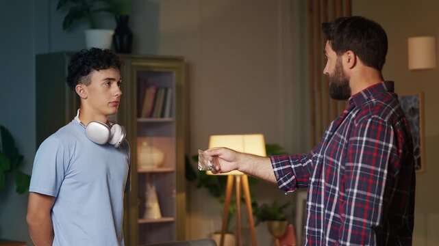Irritated father reprimanding his teenage son for smoking pot at home