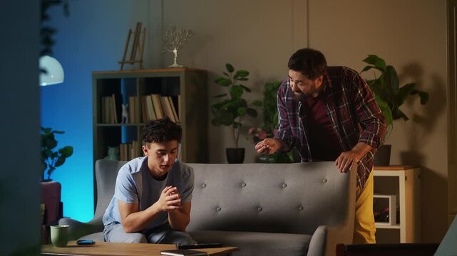 Displeased father scolding his adolescent son for poor behavior, teen phase