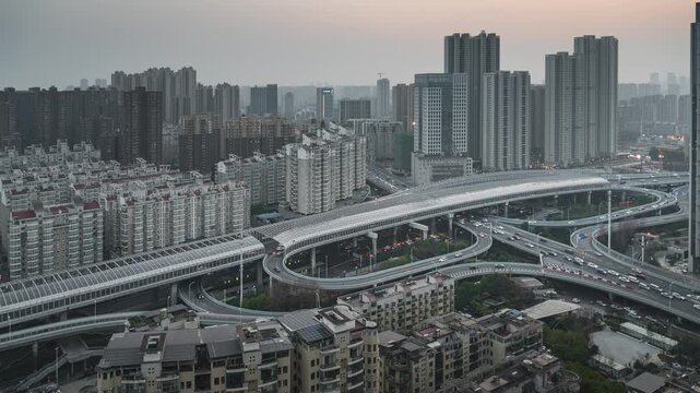 Night time-lapse of light trails on urban overpass bridge, busy traffic flow at city interchange after dark
