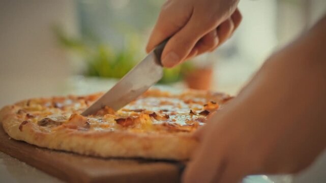 In a bright kitchen, a housewife's skilled hands carefully slice a homemade pizza on a rustic wooden board, using a simple yet effective kitchen knife to prepare a delicious meal