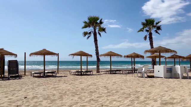 Timelapse en playa de Calpe con sombrillas y palmeras