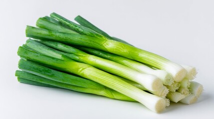 Obraz premium Green onions, ripe and fresh, sit alone on a white surface.