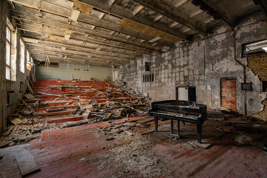 View of an abandoned auditorium with a grand piano and debris on the floor in Pripyat, Kyiv Oblast, Ukraine.