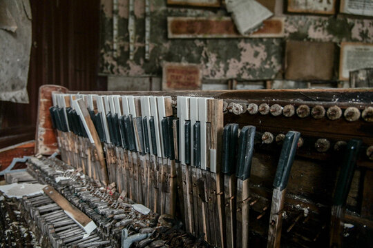 View of a broken and decaying piano keyboard inside an abandoned building with peeling walls in Pripyat, Kyiv Oblast, Ukraine.