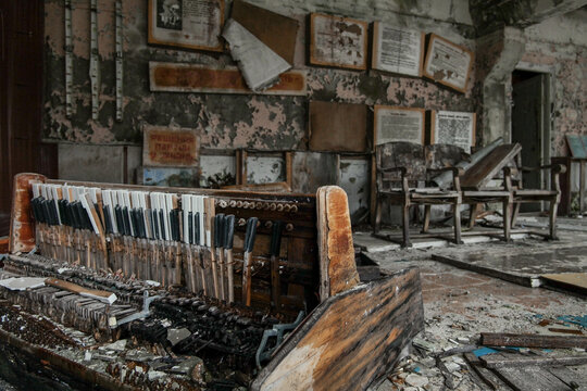 View of an abandoned piano mechanism in a decaying room with peeling paint and Soviet-era posters Pripyat, Kyiv Oblast, Ukraine.