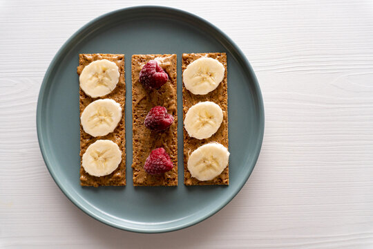 Peanut butter toast with banana and raspberry
