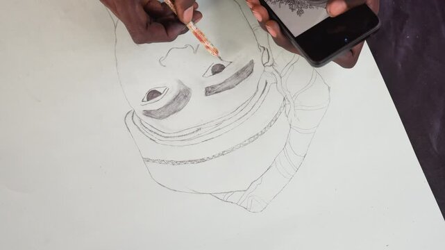 Artist meticulously paints portrait using phone. Closeup of hands crafting detailed portrait with fine brushes. Focused artist hand paints black face portrait on canvas with phone guide