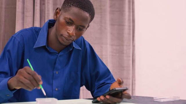 Black student painting tutorial using smartphone, step by step demonstration at table, blue shirt, closeup brushwork, warm lighting, classroom or studio workshop atmosphere, creative education and DIY