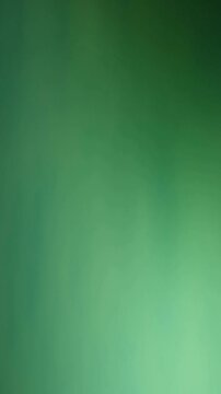 Una toma de cerca de un fondo abstracto de color verde con un efecto borroso o desenfoque en movimiento. Video vertical