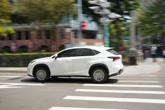 White Luxury SUV Driving on Urban City Street