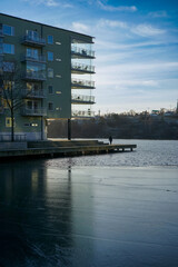 Fototapeta premium Modern waterfront apartment building by a frozen lake