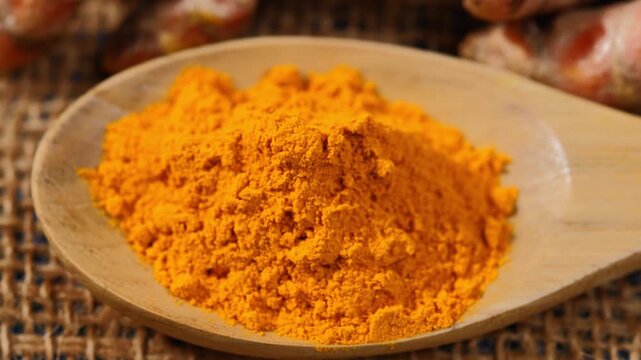Turmeric powder in wood spoon
