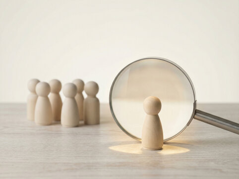 conceptual recruitment scene with magnifying glass focusing on candidate among wooden figures representing hiring selection hr analytics talent search and business leadership in modern minimal style.