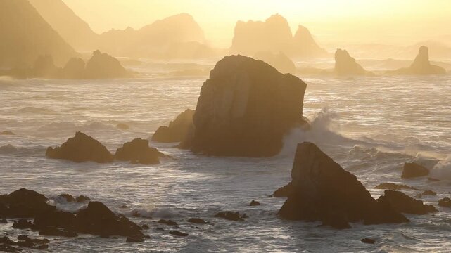 View of Silence Beach with jagged rock formations and crashing waves during golden hour in Asturias, Spain.