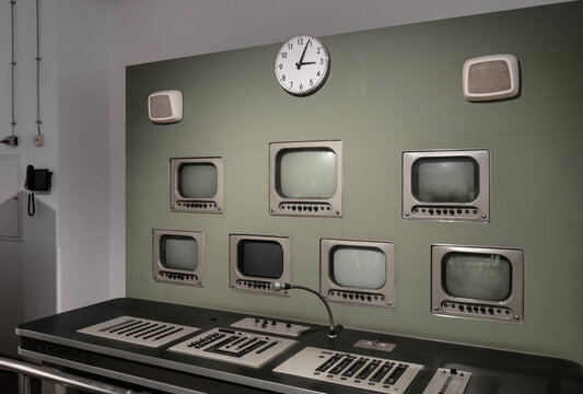 Retro TV studio control room with CRT monitors and analog console. A classic broadcasting station with an array of CRT monitors for cameras and test patterns, complete with a professional slider-drive