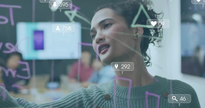 Animation of social media icons against woman writing on glass board at office