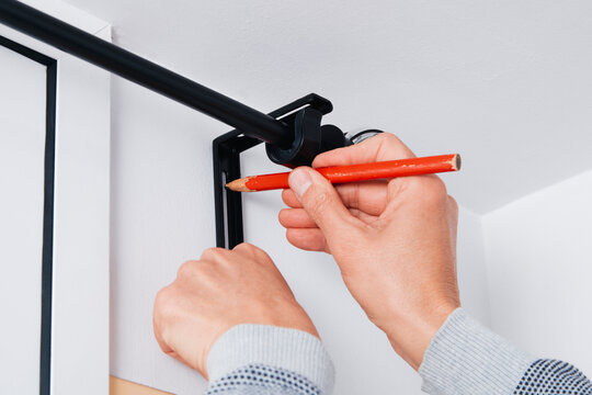 a man marks a drilling point on a wall