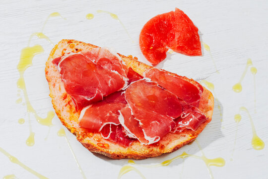 a slice of pa amb tomaquet with ham and tomato