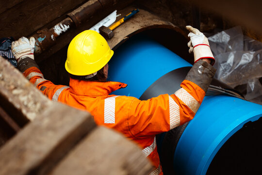 Kanalbauer auf mit blauem Rohr auf Baustelle