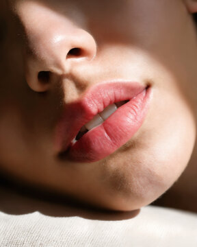 A close-up of a child's mouth with her lips slightly parted, diffused pink lips sensual