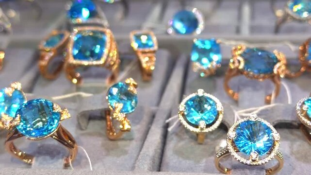 Blue topaz rings in gold settings on a jewelry store display