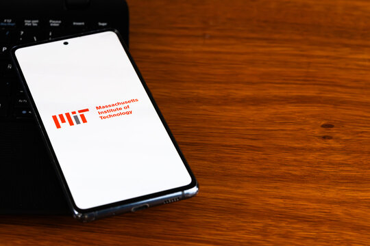 Punta Arenas, Chile &ndash; March 31, 2026: The Massachusetts Institute of Technology (MIT) logo displayed on a smartphone screen resting on a wooden desk next to a laptop