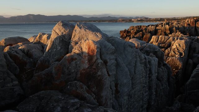 Rocky coastline, DeKelders,  South  Africa, overlooking Walker Bay Nature Reserve and Klein Mountains
