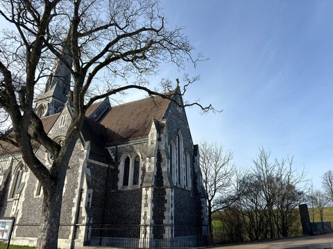 Historic Copenhagen Church Architecture: A traditional Danish church building featuring dark stone walls accented with white painted cornerstones and window trim beneath a classic shingled roof design