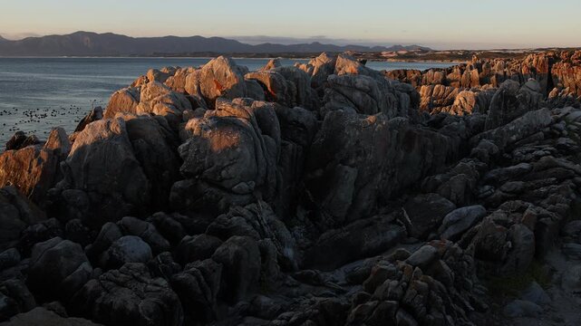 Rocky coastline, DeKelders,  South  Africa, overlooking Walker Bay Nature Reserve and Klein Mountains