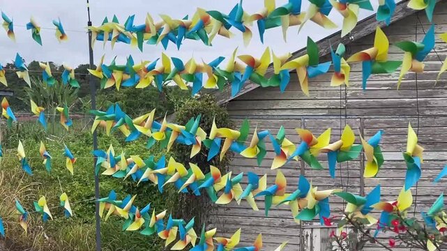 A close up shot of a rhythmic and fast spinning array of colorful pinwheels as a festive decoration in Titi Village Negeri Sembilan Malaysia in January 2025.