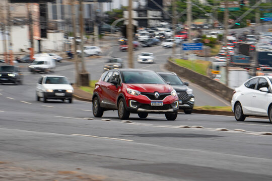 Red Renault Captur front view in movement, Compact SUV driving fast on city avenue