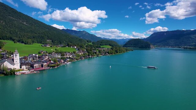 Austria Wolfgangsee 4K Aerial Drone Video Cinematic Sideways Tracking to St Wolfgang Village and Church with Lake Ferry Departing From Pier Scenic Alpine Landscape