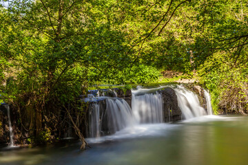 Fototapeta premium Monte Gelato waterfall surrounded by lush greenery and tranquility in Mazzano Romano, Lazio.