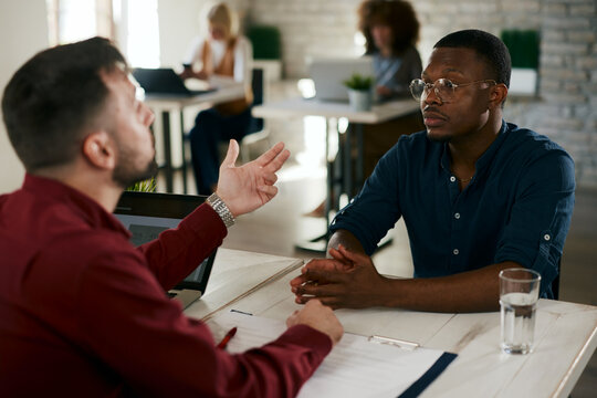 Businessman interviewing applicant during a recruitment meeting in an open space office