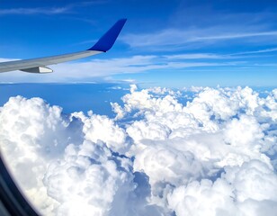 Fototapeta premium View from plane blue wing, vast clouds, and sea under sky, shot through window