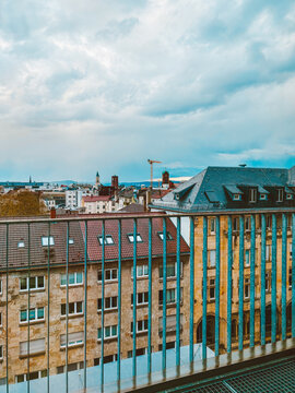 Moody European Cityscape with Historic Rooftops, Church Towers  under Dramatic Cloudy Sky