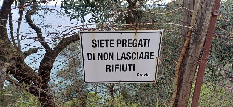 Italienisches Hinweisschild am Zaun: Bitte keinen M&uuml;ll hinterlassen (Siete pregati di non lasciare rifiuti)