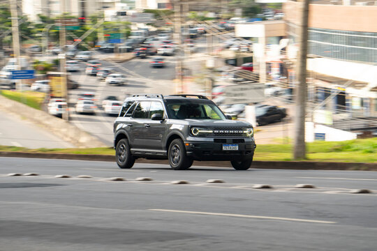 Grey Ford Bronco Sport cruising urban street, Rugged compact SUV driving on city road