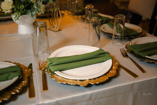 Elegant table setting with gold-toned metal decor, glassware, and floral centerpiece creating a sophisticated dining atmosphere.