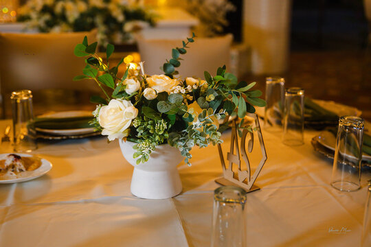 Elegant table setting with gold-toned metal decor, glassware, and floral centerpiece creating a sophisticated dining atmosphere.