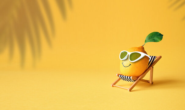 Lemon in sunglasses relaxes on lounge chair on beach. Summer tropical minimal humor concept.